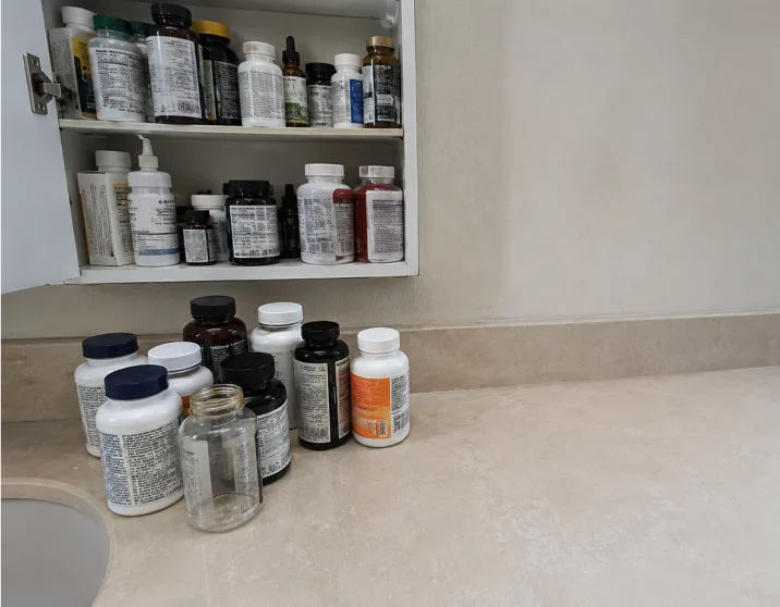 A bathroom shelf of supplement bottles from six different brands